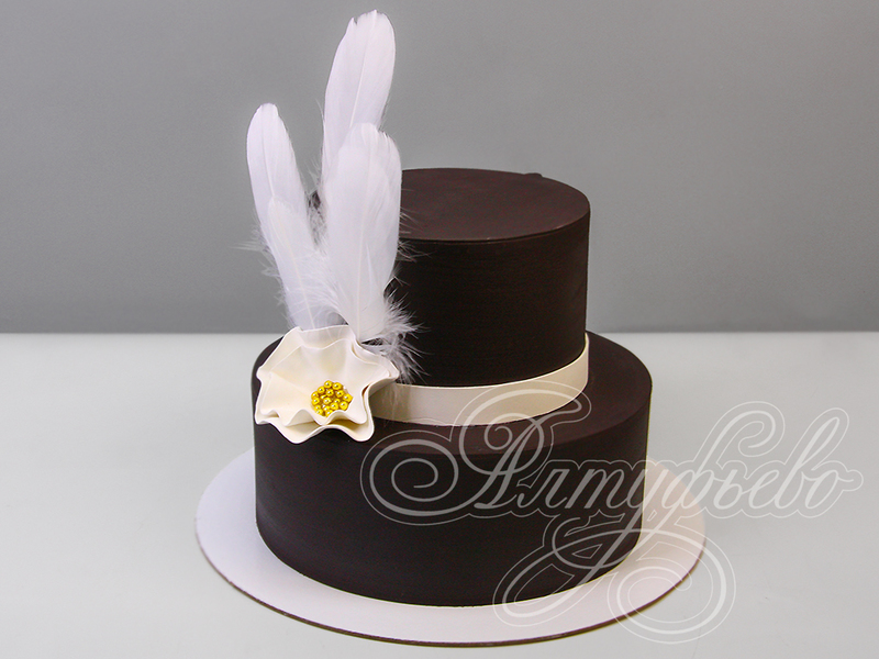 Торт двухъярусный темного цвета с белым цветком и белыми перышками