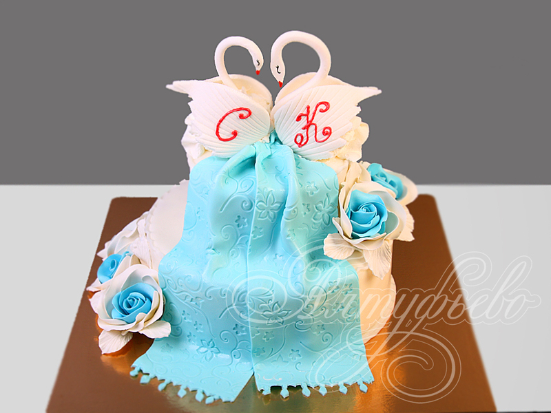 Свадебный торт с голубыми розочками и белыми лебедями