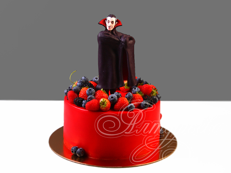 Красный торт с фигуркой Дракулы и ягодами